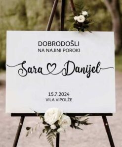 Na tabli je napis dobrodošli na najini poroki, zraven so imena ženina in neveste, spodaj pa je datum in kraj poroke.